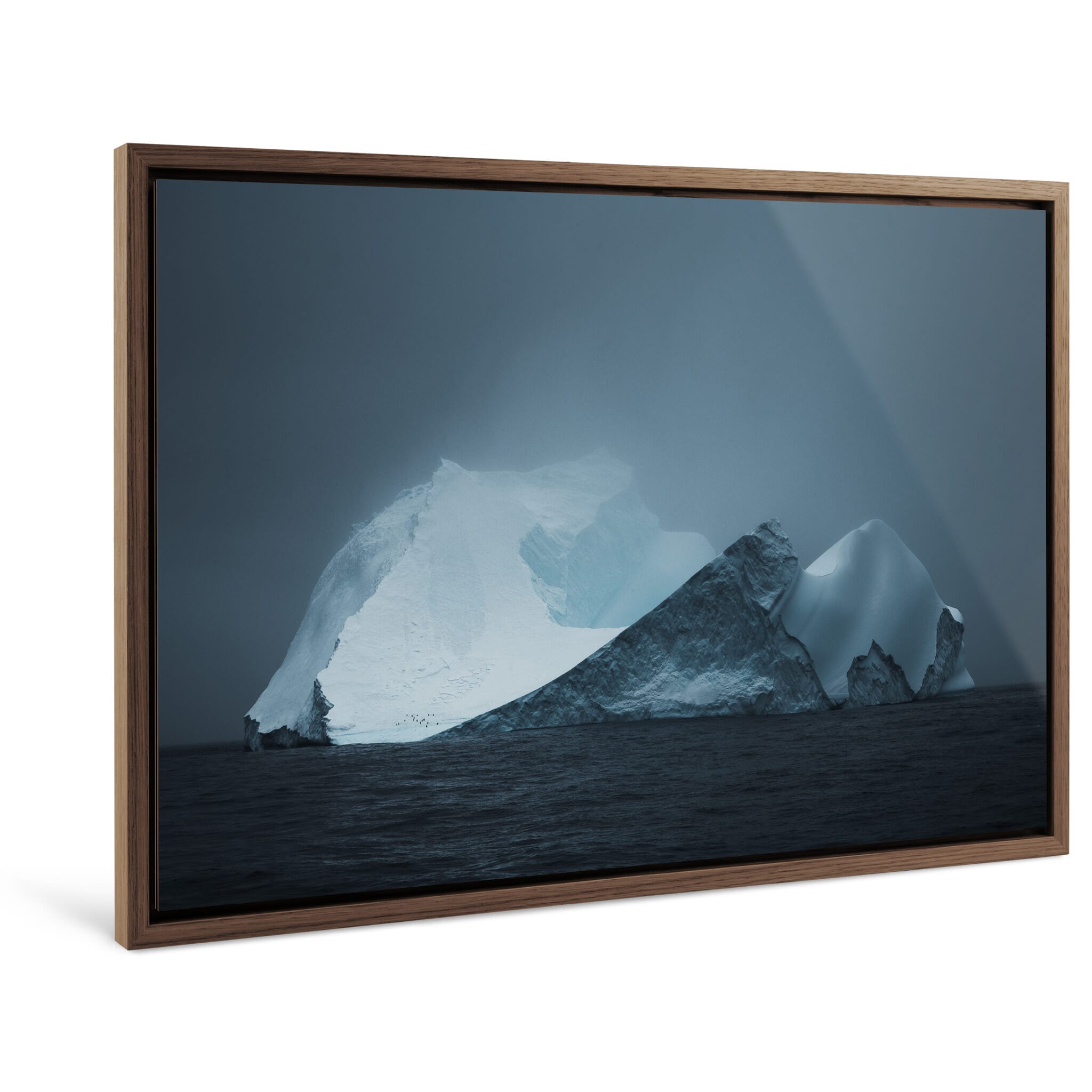Framed photo print of towering iceberg under shifting light and heavy clouds