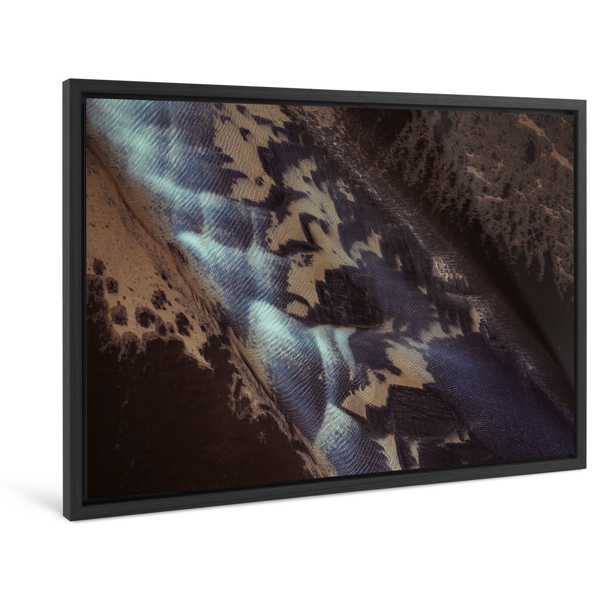 Framed photo print of glacial river sediment creating swirling shapes in the sand