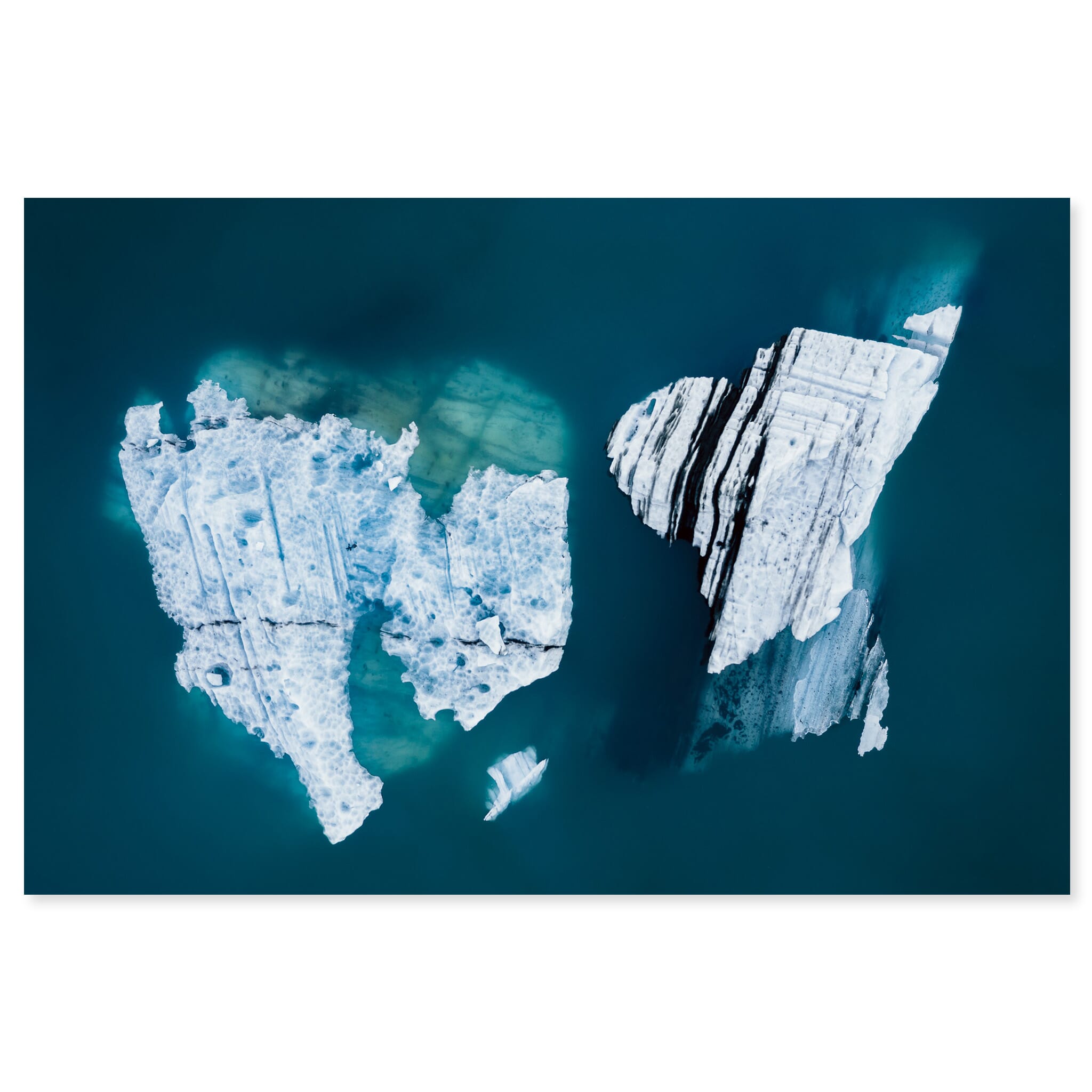 Fine art print of an aerial view of an iceberg floating in a turquoise glacial lagoon in Iceland