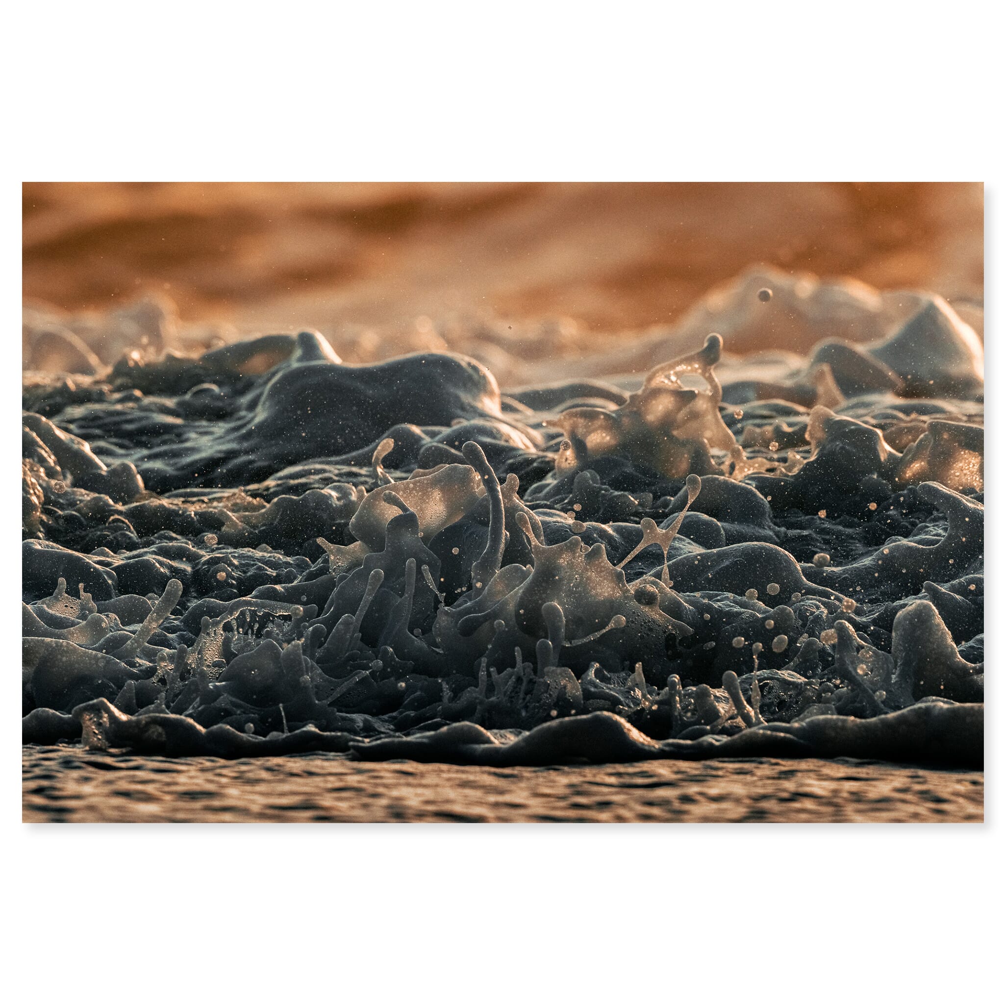Fine art print of a close-up wave on Iceland’s black sand beach under warm sunrise