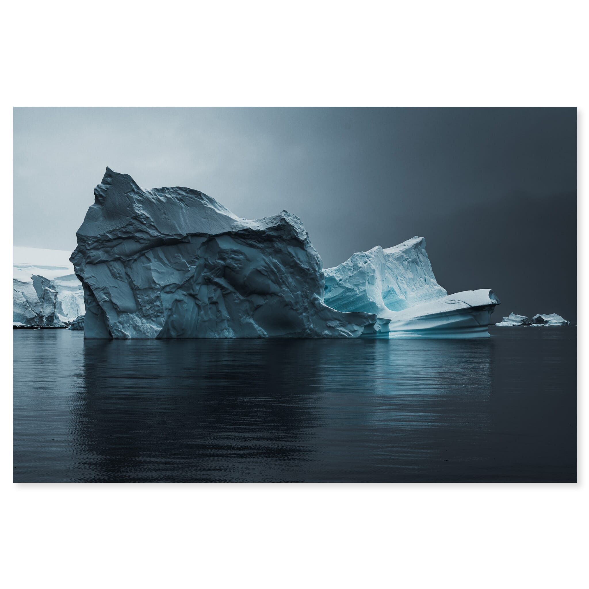 Fine art print of an Antarctic iceberg with deep textures under a dark sky