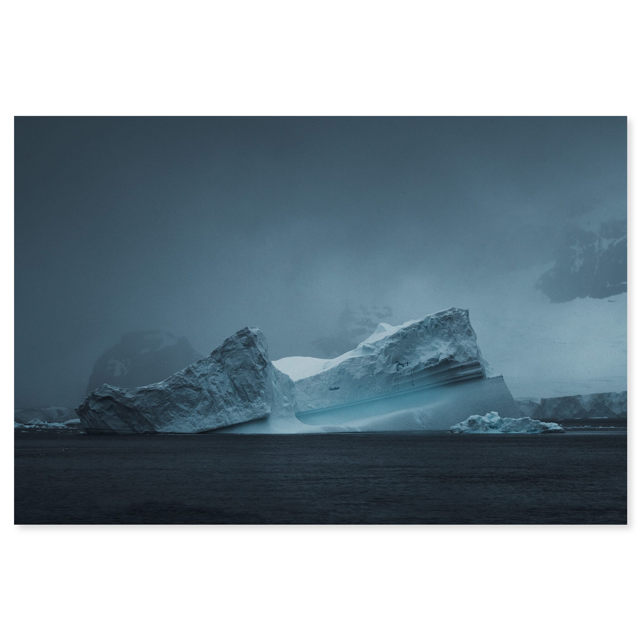 Fine art print of isolated Antarctic iceberg under dramatic light in a dark seascape