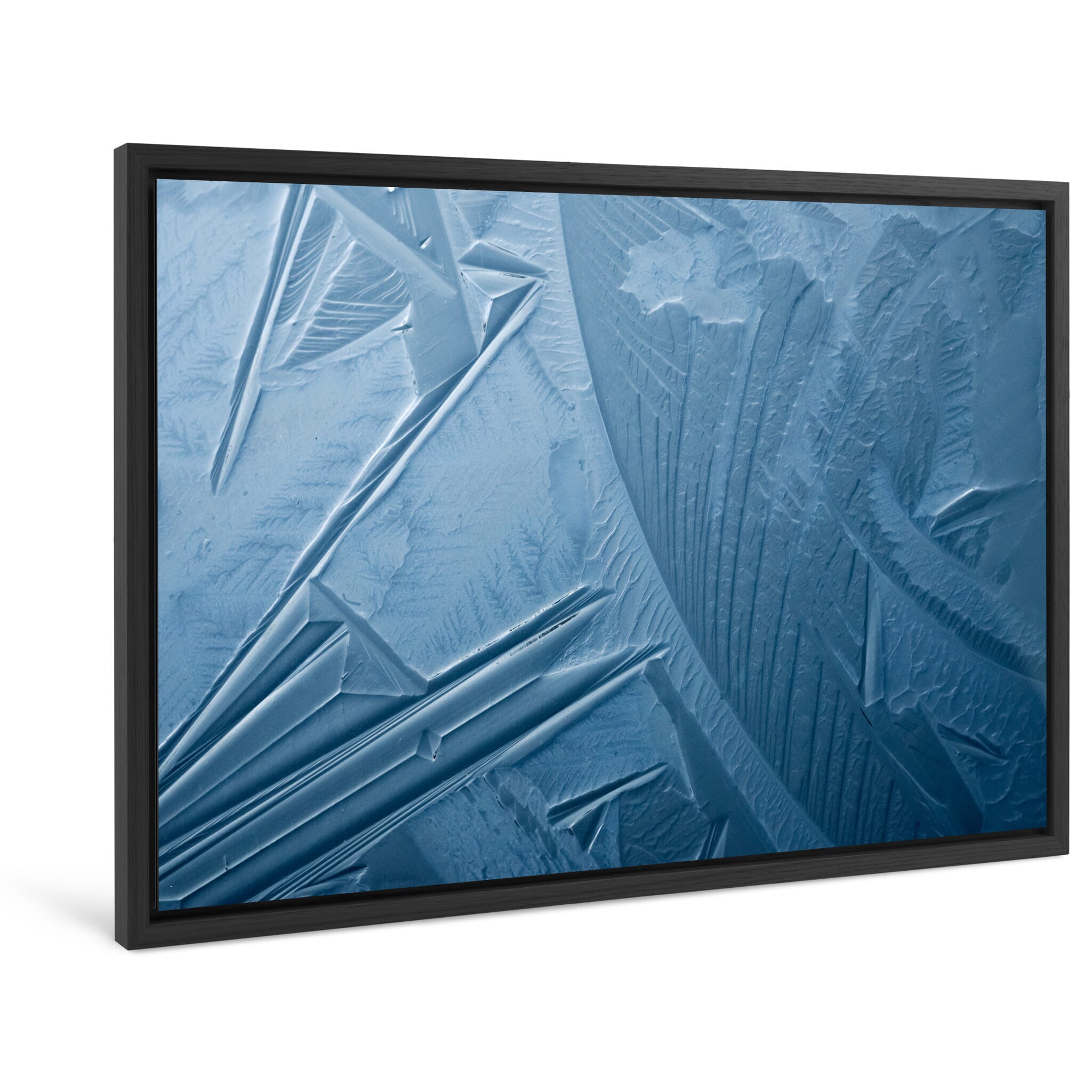 Framed photo print of sharply defined ice formations on winter puddles