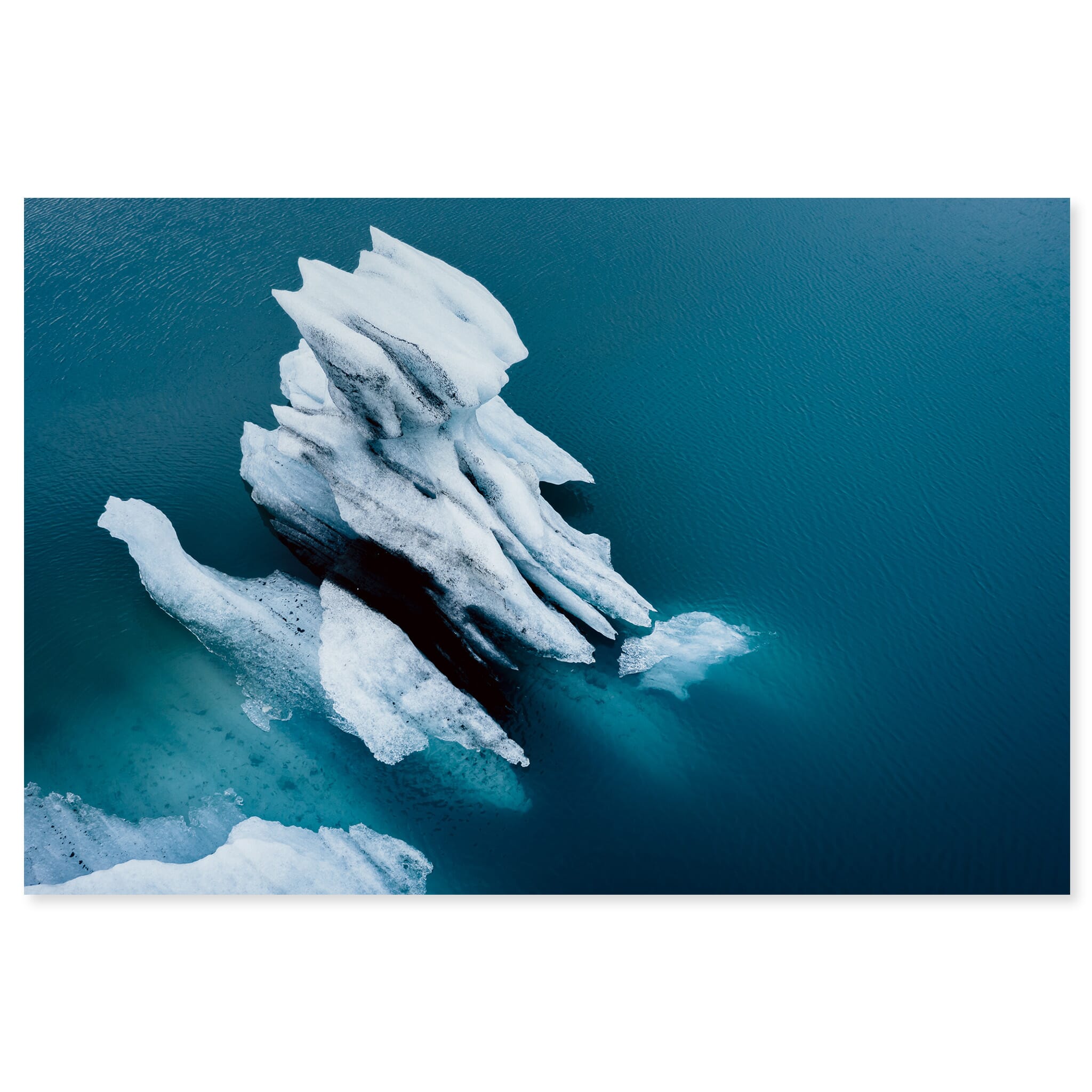 Fine art print of an aerial view of an iceberg floating in a turquoise glacial lagoon in Iceland